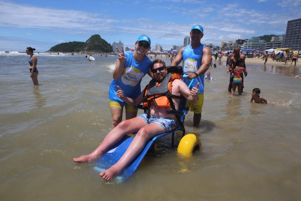 Pessoas com mobilidade reduzida podem tomar banho de mar em cadeiras adaptadas nas praias do litoral paranaense